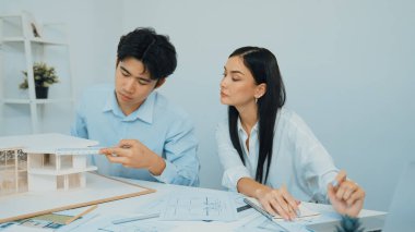 Profesyonel erkek mühendis ev modelini cetvel kullanarak ölçerken güzel bir kooperatif iş arkadaşı verileri analiz etmek için dizüstü bilgisayar kullanarak birlikte çalışıyor. Yaratıcı tasarım ve takım çalışması. - Yakın çekim. Tertemiz..