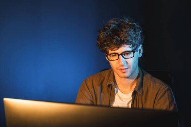 Genç işadamı, Neon Light Modern Ofis 'te yaratıcı bir başlangıç projesi için bilgisayara odaklanıyor. Düşünüyorum da, pazarlama ağı yaratıcıdan pazar kanalı tasarım konseptine çevrimiçi planlama. Toplayıcı.