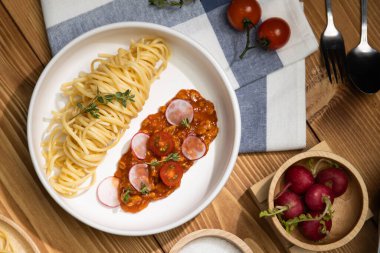Lezzetli yiyecekler, ev yapımı spagetti, kıymalı domates sosu ve fesleğen fırlatma elementleri, şef masası dekoratif baharatlarla servis ediliyor. Varsayım.