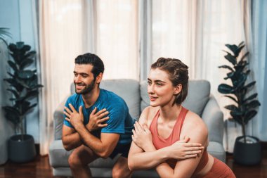 Atletik ve sportif çift evde vücut egzersizi yaparken evde sağlıklı fiziğe ve spor yaşam tarzına uyum sağlamak için birlikte oturuyorlar. Gaiety ev egzersizi antrenman konsepti.