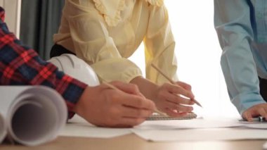 Mimari döküman, ölçüm araçları ve ahşap blokların modern ofiste etrafa saçıldığı masa üzerine planlar yapma konusunda akıllı mimar ve güvenlik mühendisi tartışması. - Yakın çekim. Tanımlama.