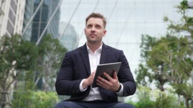 Tablet kalem kullanarak ve pazarlama stratejisi planlayarak parkta oturup tablet yazan işadamlarına yakın çekim yapın. Yönetici finansal planı düşünürken veri analizine bakıyor. Urbane