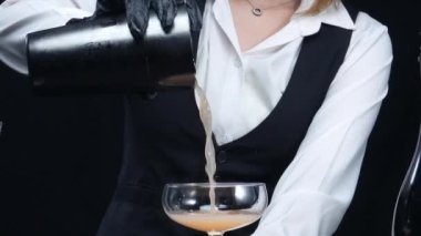 Akıllı barmene yakın dur. Barda ve modern barda portakal ve biberiyeyle kokteyl hazırla. Profesyonel barmen elleri siyah arka planda kan turuncu negroni yapıyor. Ağır çekim. Geliştirilebilir.