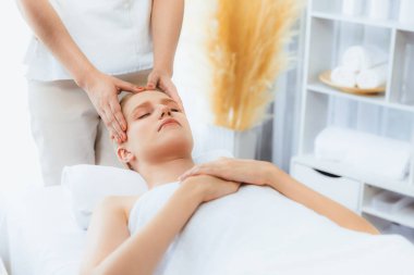 Kafkasyalı kadın stres önleyici kafa masajından ve lüks tatil beldesi ya da otel spa salonundaki modern ışık ortamında yüz güzelliği eğlencelerini şımartmaktan hoşlanıyor. Sessiz.