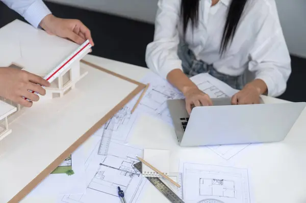 stock image Professional engineer measures house model while skilled designer writes down in blueprint. Work together, collaboration, cooperate. Creative design and team working concept. Top view. Immaculate.