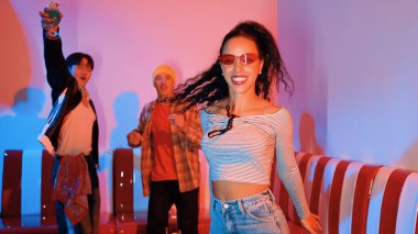 Çok kültürlü bir arkadaş birlikte dans ediyor ve hiphop müziği eşliğinde restoranda ya da kafede pembe neon ışıklı duruyor. Profesyonel sokak dansçıları grubu enerjik hareketler sergiliyor. Mutluluk.