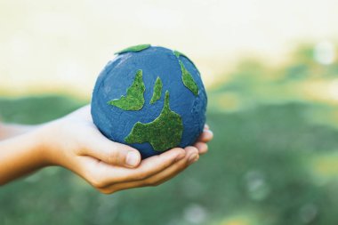 Dünya gezegenini ESG ilkesi ve çevre dostu enerjisiyle daha parlak bir gelecek için Dünya günü olarak el ele tutuşan genç çocuklar. Döngü