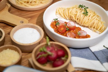Lezzetli yiyecekler, ev yapımı spagetti, kıymalı domates sosu ve fesleğen fırlatma elementleri, şef masası dekoratif baharatlarla servis ediliyor. Varsayım.