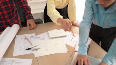 Mimarlık ve güvenlik mühendisi, modern ofiste doğruluk için mimari belge ve ölçüm aracı kullanılarak dizüstü bilgisayarın üzerinde sergilenen planlar hakkında tartıştı. - Yakın çekim. Tanımlama.
