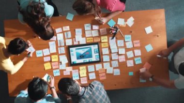 Tablet kablo prototipine bakarken, web tasarımı hakkında beyin fırtınası yapan ve planlayan programcıların tepeden tırnağa görüntüsü. Yetenekli müteahhit takımının dijital uygulamadan bahseden hava görüşü. Sempozyum.