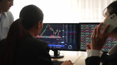 Hisse senedi borsası pazarlamasını analiz eden yavaş çekim şirketindeki yatırımcılar, kayıp için mum bar fiyatını analiz eden monitörlere bakıyor ve kazanç ve kâr elde ediyor. Filizlenen
