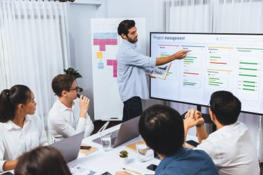 Proje yöneticisi monitörde proje yönetimi yazılım görüntülemesi, proje görevinin ilerlemesini izlemek ve toplantı masasında program planı yapmak suretiyle ekiple iletişim kurar ve işbirliği yapar. Tedbirli