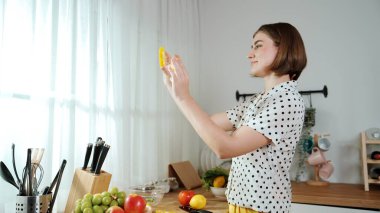 Mutlu anne sebze doğruyor ya da salata yapıp kameraya poz veriyor. Evin bekçisi kameraya bakarken taze malzemeler hazırlar. Modern mutfakta mutfak gereçleriyle yemek pişiren zeki bir anne. Pedagoji.