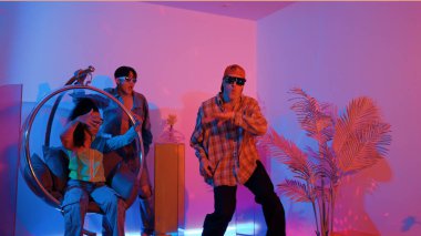 Stüdyoda gündelik kıyafetleri olan çok kültürlü bir arkadaş tezahürat yaparken mutlu hipster break dansları. Profesyonel sokak dansçısı hip hop ritmi ya da neon veya kurşun ışıkla kafiyeli bir şarkı söyler. Mutluluk.