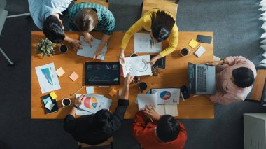 Becerikli iş adamlarının pazarlama fikrine ilişkin üst düzey bir görüş, bir grup yatırımcı hisse senedi borsası grafiği veya veri analiz belgesine bakarken dinleme ve planlama stratejisi sunarken ortaya atıldı. Cemaat.