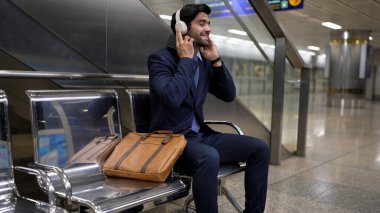 Tren istasyonunda oturmuş müzik dinleyen yetenekli bir iş adamı. Profesyonel Kafkas proje yöneticisi tren ya da metro bekliyor. Erkek lider dinlemekten hoşlanır. Takım elbiseli rahat müzik. Sevinçli..