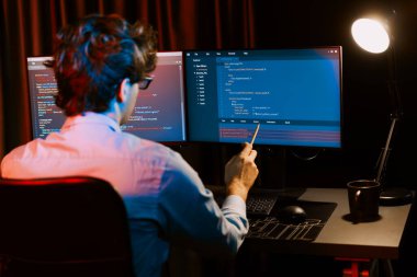 Uygulama pc ekranları ile çevrili çevrimiçi yazılım geliştirme bilgilerini yoğunlaştıran IT geliştiricisi, neon modern ofis evindeki web sitesinde yazılım için program yaratıyor. Toplayıcı.