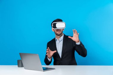 Bilgisayarla masada otururken ve VR gözlüğü takarken veri analizine bakan yetenekli bir iş adamı. Proje yöneticisi sanal gerçeklik sistemini kullanarak ya da metaevrende bağlantı kurarak çalışıyor. Sapma.