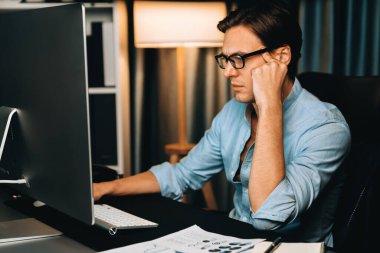 Dinamik veritabanı pazarlama analizi ile PC ekranındaki iş paragrafını araştıran stresli finansal analistin gece vakti modern ev ofisinde aylık rapor hazırlamasını düşünüyorum. Bireysel.