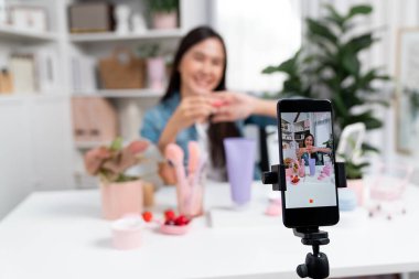 Kozmetik makyaj makyajı, ruj, pastel renkler, sosyal medyada kol testi promosyonunda en çok satan kitaplar koleksiyonunu gösteren seçici odaklı telefon. Taktik.