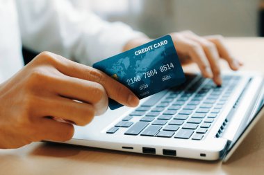 Genç adam, laptop bilgisayar başvurusu ya da web sitesinde online alışveriş yapmak için kredi kartı kullanıyor. E-ticaret ve online alışveriş konsepti. uds