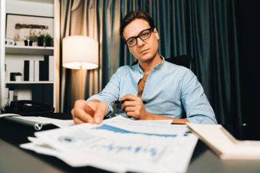 Akıllı iş adamının elinde evrak raporları var. Paragraf dinamik veritabanı, küresel hedef değerlendirme değeri kar şirketini analiz eden bilgisayar ekranına bakıyor. Bireysel.