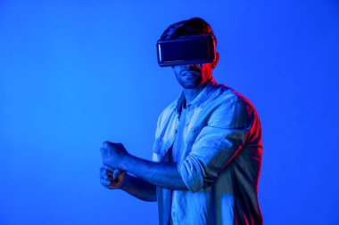 Kafkasyalı bir adam VR cam takıyor ve hareket eden el kol kılıcını tutuyor. Oyuncu, gelecekteki sanal gerçeklik kulaklığını ya da gelecekteki yenilikleri kullanarak meta dünyaya giriyor ya da aksiyon oyunu oynuyor. Sapma.