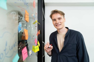 Kafkasyalı profesyonel iş adamının zihin haritası ve renkli yapışkan notlar kullanarak iş pazarlama fikrini kendine güvenle sunuşunun yakın görüntüsü. Proje konseptini başlat. Portre. Tertemiz..