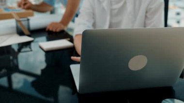 Akıllı mimar mühendis ev modelini incelerken meslektaşı da laptop analiz verilerini kullanıyor. Modern ofisteki ev modeli inşaatında profesyonel tasarımcı takımı birlikte çalışıyor. İzleme