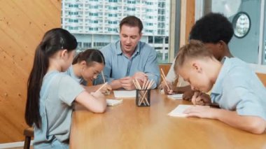 Sıradan tişörtlü zeki liseli çocuk, karışık ırkları olan öğrenciler kitap yazarken profesyonel öğretmene soruyor. Yaratıcı çocuk notayı işaret ederken Kafkas eğitmeni yorum yapıyor. Öğretim