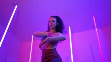 Latin dansçıların kameraya bakıp şehrin pop müziğiyle dans ettiği düşük açılı kamera. Profesyonel çekici hipster, mor veya neon ışıklı hip hop şarkısına geçiyor. Şık bir kumaş. Mutluluk.