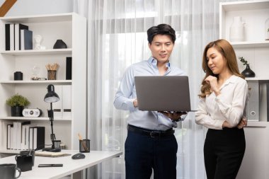 Gülümseyen Asyalı iş arkadaşları modern ofiste dizüstü bilgisayar pazarlama projesi hakkında konuşurken. Yeni sosyal medya kanalında başarılı müşteri ihtiyaçları analiz ediliyor. İnfobahn.