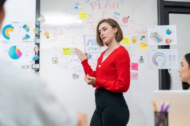 Profesyonel çekici kadın lider, modern iş toplantı odasında beyin fırtınası zihin haritalama istatistikleri ve renkli yapışkan notlar kullanarak yaratıcı pazarlama planını sunuyor. Tertemiz..