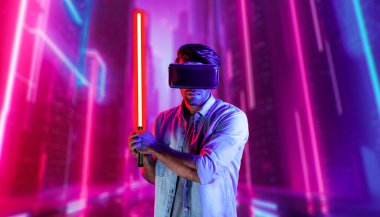 Lazer kılıcı tutan ve VR gözlük takan oyuncu. Beyaz adam, neon şatonun etrafında dikilirken görsel gerçeklik kulaklığı kullanıyor. Yenilik teknolojisi. Sapma.