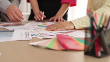 Grafik tasarımı için beyin fırtınası yapan ve renk seçimi yapan tasarımcı ekibinin yavaş çekim çekimi veya tasarım bürosunda krom danışmanlığı için danışmanlık isteyen bir müşteri. Değiştirilmiş