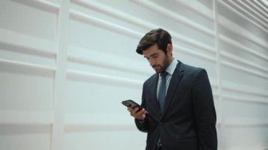 Yetenekli yönetici, iş arkadaşıyla proje hakkında konuşmak için telefon görüşmesi yapıyor. Yakışıklı erkek lider, beyaz arka planda dururken iş ekibini arayıp satışlar hakkında konuşmak istiyor. Sevinçli..