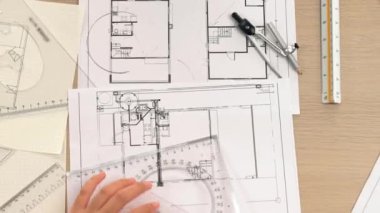 Akıllı mimar ya da akıllı mühendisin ölçüm aracı ve ahşap kalem el kullanarak mimari ofisindeki inşaat isabetinin planının detaylarını yazdığı bir video. Eline odaklan. Tanımlama.