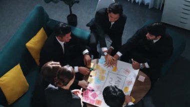 Profesyonel iş adamlarının el ele tutuşup başarılı bir projeyi kutlamak için el çırpışları ve beyin fırtınası fikrini zihin haritalamada kullanışları. Sevgi ve birliği temsil ediyordu. Müdürlük.