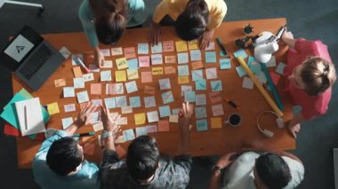 Akıllı proje yöneticisinin konuşmasının ve fikir ve alkışlamayı açıklamasının üst görüşü. İş dünyasının havadan görünüşü başarılı projeyi alkışlıyor. Toplantı odasında el çırpma takımının hava görüntüsü. Sempozyum.