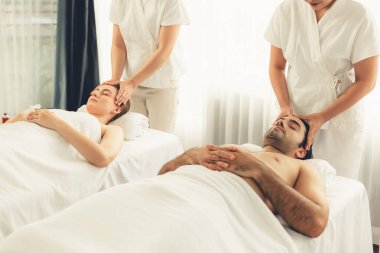 Kafkasyalı çift stres önleyici kafa masajının keyfini çıkarıyor ve lüks otellerde ya da otel spa salonlarında gündüz kaplıcalarında yüz güzelliği eğlencelerini şımartıyor. Sessiz.