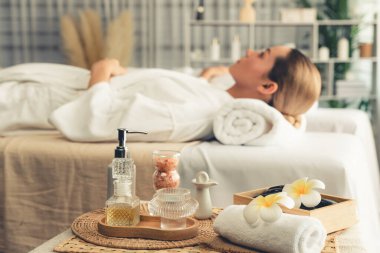 Aromaterapi masajı gündüz atmosferinde ya da spa salonunda bulanık bir kadına odak dekor ve spa aksesuarları kurarak tatil köyünde ya da otel arka planında keyifli aroma spa masajı yapan bir masaj. Sessiz.