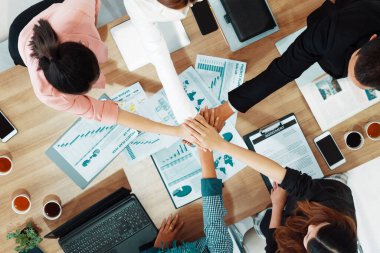 İş adamları ve iş kadınları, takım çalışması, destek ve iş birliğini gösteren çok kültürlü ofis odasındaki grup toplantılarında el ele tutuşuyorlar. Çeşitli işyerleri ve şirket çalışanları konsepti. uds