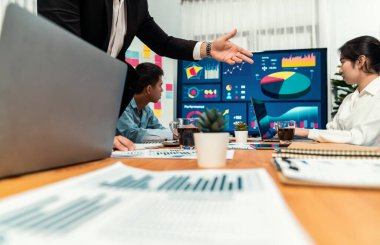 Finansal veri raporunu analiz eden çeşitli bir grup iş analisti. Mali veri analiz çizelgesi ve grafik paneli stratejik pazarlama planlama için toplantı odasında TV ekranında. Habiliment