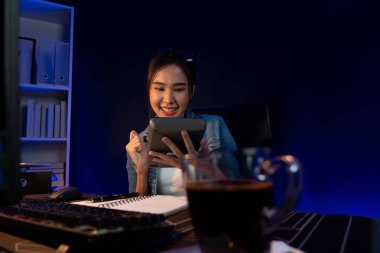 Başarılı genç, güzel Asyalı yaratıcı hesaplama rakamı. Sosyal medyadaki satış hedefi raporundan elde edilen kazanç. Neon ışığı gecesinde yeni bir strateji planlamak için serbest meslek sahibi olmak. Taktik.