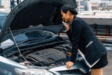 Arabası arızalı genç bir iş kadını yol yardımı için cep telefonu kullanıyor. Seyahat ve ulaşım aracı sorunu. uds