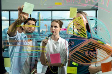 İş arkadaşı plan yaparken cam duvarı işaret eden yetenekli bir proje yöneticisi. Çeşitli iş adamları birlikte çalışıyor, pazarlama fikri ya da iş planı üzerinde kafa yoruyorlar. Yaratıcı bir başlangıç. İzleme.