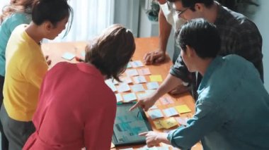 Ux Ui tasarımı kullanılarak dijital program ve yazıları tartışan ve gösteren geliştirici ekibin hava görüntüsü. İş dünyasına tepeden bakan insanlar telefon ve bilgisayar için kablo prototipi geliştiriyorlar. Sempozyum.