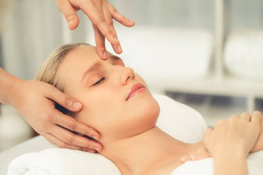 Kafkasyalı kadın stres önleyici kafa masajından ve lüks tatil beldesi ya da otel spa salonundaki modern ışık ortamında yüz güzelliği eğlencelerini şımartmaktan hoşlanıyor. Sessiz.