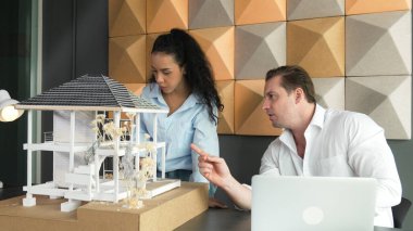 İki usta mimar mühendis takımı ev modeli yapısı hakkında konuşuyor. Ev tasarımı için proje yöneticisi birlikte çalışıyor. Beyin fırtınası. İş tasarımı konsepti. Yönlendirici..