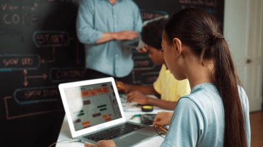 Öğretmenler kodlama sistemini öğretirken, farklı akademik öğrenciler STEM teknoloji sınıfında ana tahtayı dizüstü bilgisayar programlama programlama komut veya mühendislik koduyla düzeltiyorlar. Öğretim.